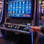 A player tapping a contactless card on a slot machine card reader on a casino floor