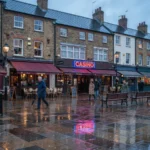 Casino sign lit above restaurants on a British town centre street at night
